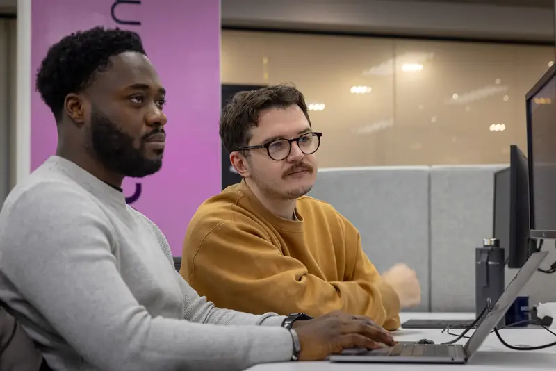 Two colleagues talking at a desk