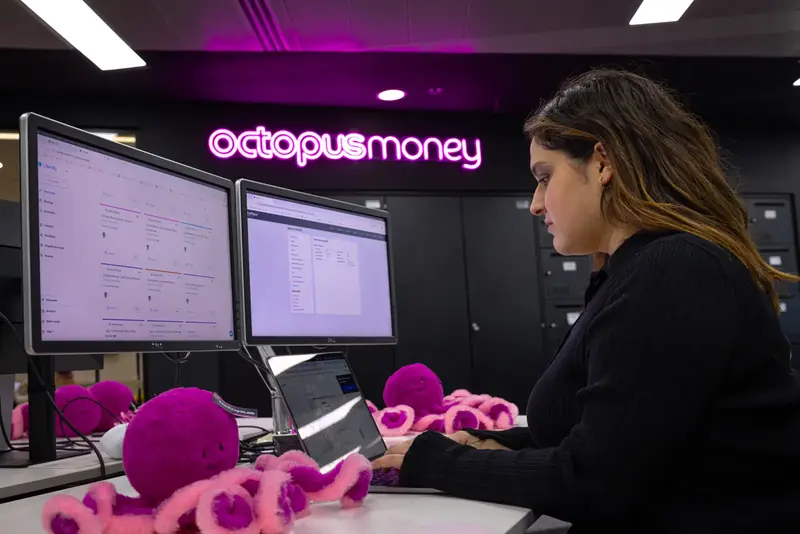 A colleague working under the Octopus Money neon sign