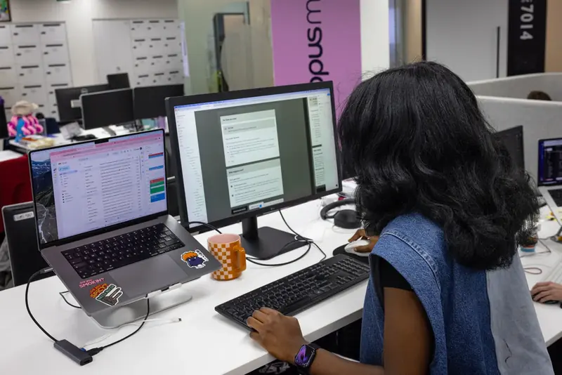 A colleague at her desk with two screens